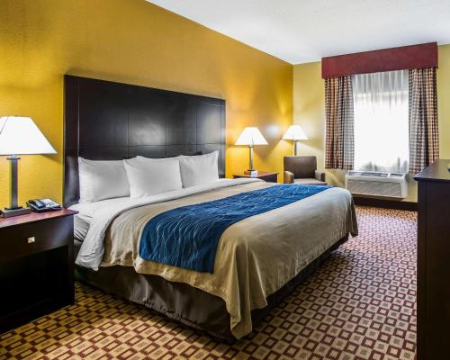a hotel room with a large bed and a chair at Quality Inn Plant City - Lakeland in Plant City