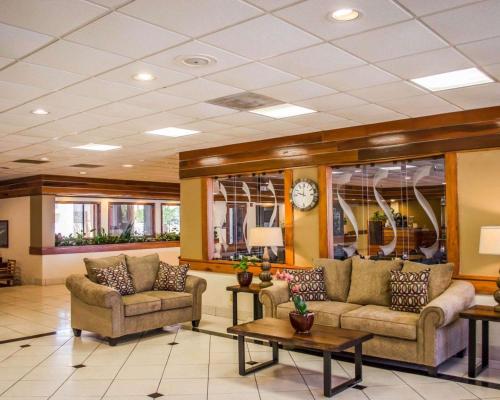 a lobby with couches and tables and a clock at Quality Inn & Suites Pensacola Bayview in Pensacola