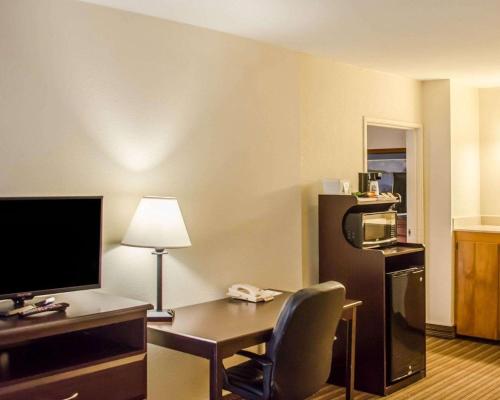 a hotel room with a desk with a computer and a chair at Quality Inn & Suites Pensacola Bayview in Pensacola
