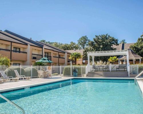 a swimming pool with a gazebo next to a building at Quality Inn & Suites Pensacola Bayview in Pensacola