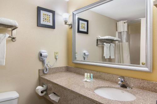 a bathroom with a sink and a mirror and a toilet at Quality Inn & Suites Union City - Atlanta South in Union City