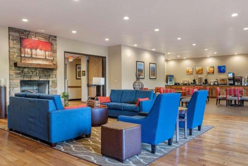 Elle comprend un salon doté d'un mobilier bleu et d'une cheminée. dans l'établissement Comfort Inn & Suites Blue Ridge, à Blue Ridge