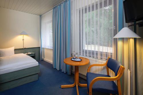 a hotel room with a bed and a table and a window at Gastehaus Chorin in Chorin