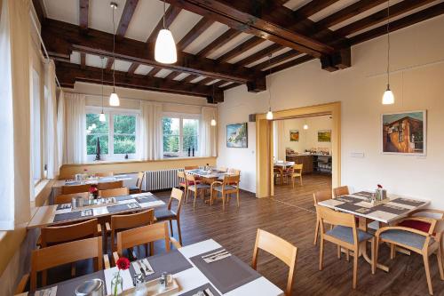 ein Restaurant mit Tischen und Stühlen in einem Zimmer in der Unterkunft Gastehaus Chorin in Chorin