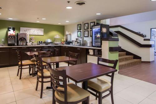 a restaurant with tables and chairs and a staircase at Sleep Inn Atlanta Airport in Atlanta