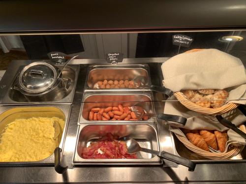 Un buffet con muchas bandejas de comida y otros alimentos. en Hotelli Peltohovi, en Kiuruvesi