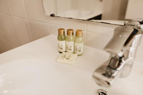 two bottles of alcohol sitting on top of a bathroom sink at Boutique Hotel Voskresensky in Istra