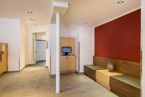 a hallway with a room with a tv and a column at Sure Hotel by Best Western Muenchen Hauptbahnhof in Munich