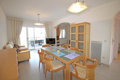 comedor y sala de estar con mesa y sillas en Apart-rent Apartment Sant Maurici 0183, en Empuriabrava