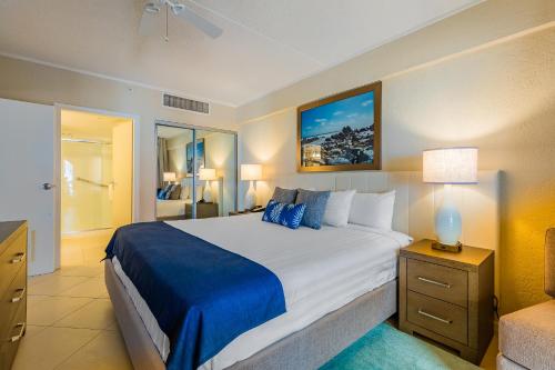 een slaapkamer met een groot bed en een blauwe deken bij Playa Linda Beach Resort in Palm-Eagle Beach