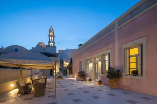 an outdoor patio with a clock tower in the background at Aria Lito Mansion in Fira