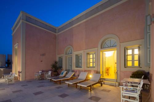 a large patio with couches and chairs on it at Aria Lito Mansion in Fira