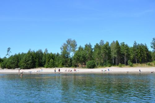 a group of people on a beach near the water at Marbyfjärden seaside village Lyckan in Eckerö