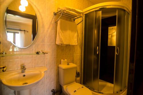 a bathroom with a sink and a toilet and a mirror at Meldi Hotel in Kalkan