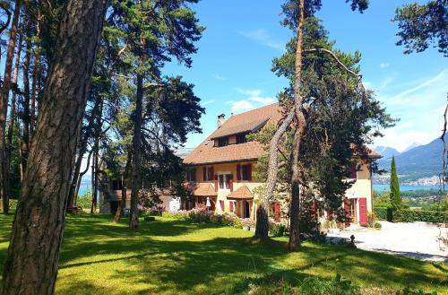 a house in the middle of a yard with trees at Les Ô d'Annecy in Saint-Jorioz