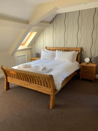 a bedroom with a wooden bed with white sheets and pillows at Castle house in Knaresborough