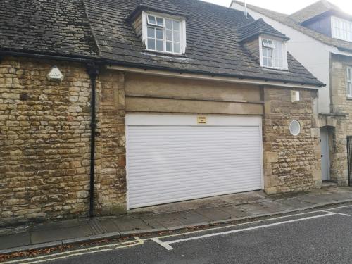 a garage with a white garage door on a brick building at Meadow House in Stamford
