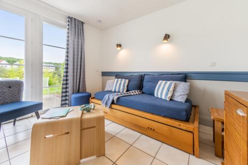 a living room with a blue couch and a table at Village Pierre & Vacances Belle Dune in Fort-Mahon-Plage