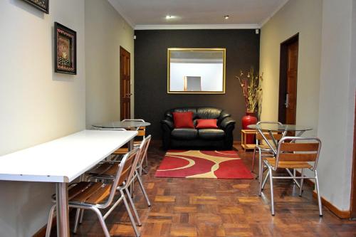 sala de estar con mesa, sillas y sofá en Houghton Guest House, en Johannesburgo
