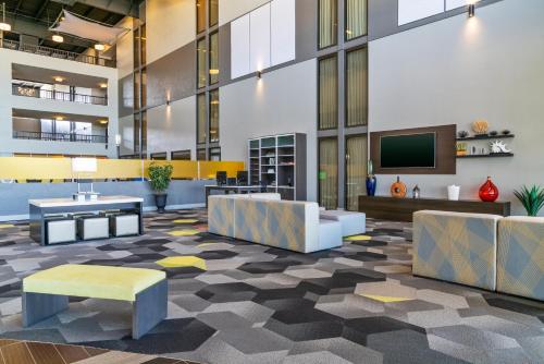 an office lobby with a tv and couches at Holiday Inn Morgantown - Reading Area by IHG in Morgantown