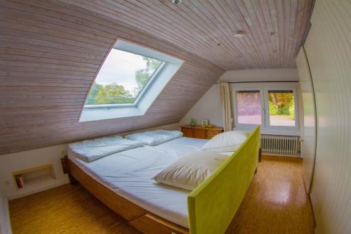 a bedroom with a large bed with a window at Ferienhaus im Bestetal in Bad Oldesloe