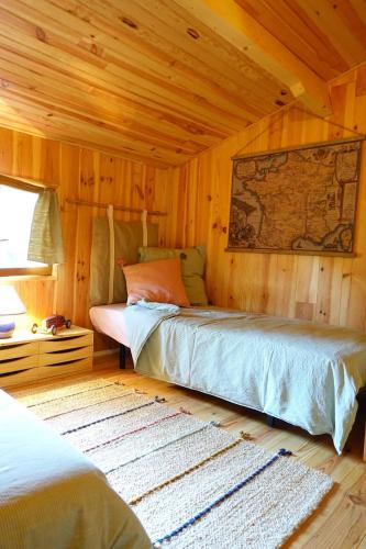 une chambre avec un lit dans une pièce en bois dans l'établissement LE COULOUMAT Saucats, à Saucats