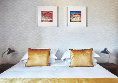 um quarto com duas fotografias na parede e uma cama em Garrison Apartments em Fort William