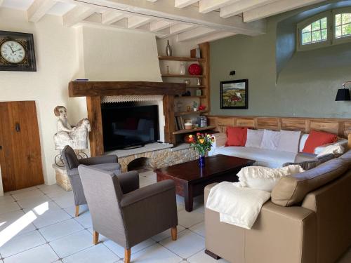 a bedroom with a bed and a living room with a fireplace at Le Clos St Georges in Entraygues-sur-Truyère