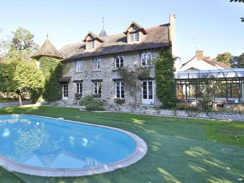 une grande maison avec une piscine devant dans l'établissement Le Clos Saint Lubin, à Nainville-les-Roches