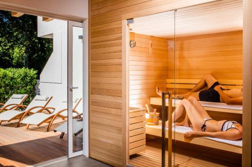 a sauna with two women laying on beds at Villaggio Los Nidos in Lignano Sabbiadoro