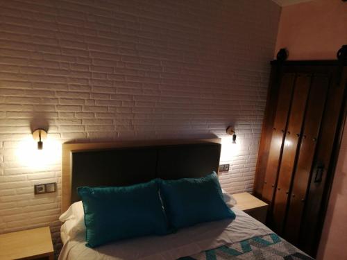 une chambre avec un lit avec deux oreillers bleus dans l'établissement Apartamento Buenavista con Jacuzzi y Jardín privado en Abadia ATT-CC-0608, à Abadía