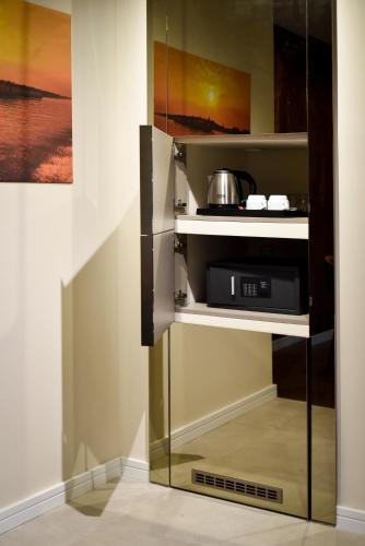 a glass cabinet with a microwave in a kitchen at Hotel LoRa in Belgrade