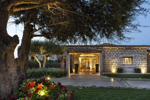 an entrance to a home with a tree at Hotel Li Finistreddi in Cannigione