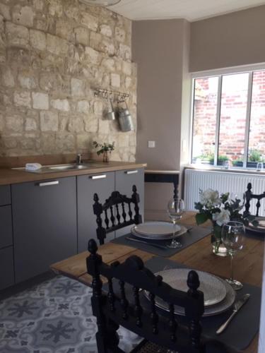 a kitchen with a table and a dining room at Les Amandiers in Bouvigny-Boyeffles