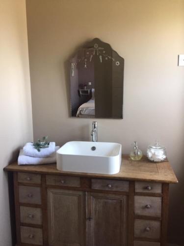 une salle de bain avec un lavabo et un miroir dans l'établissement Les Amandiers, à Bouvigny-Boyeffles