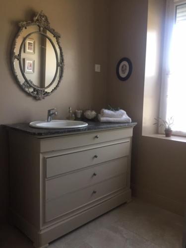 a bathroom with a sink and a mirror at Les Amandiers in Bouvigny-Boyeffles