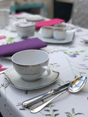 a table with a cup and a plate and spoon at Le Clos Saint Lubin in Nainville-les-Roches
