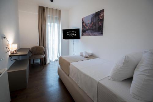 a hotel room with a bed and a desk and a television at Hotel LoRa in Belgrade