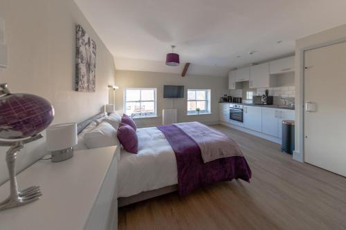 Isabella House - Hereford City Centre Aparthotel, By RentMyHouse في هيريفورد: غرفة نوم بسرير كبير ومطبخ