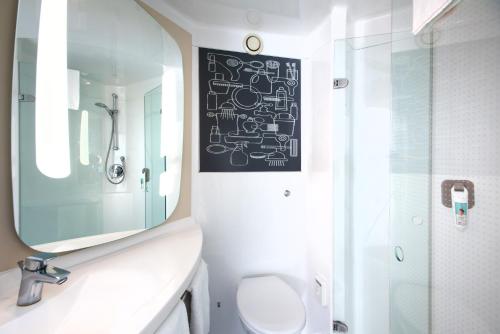 a bathroom with a sink and a mirror and a toilet at Ibis Sheffield City in Sheffield