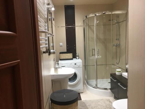 a bathroom with a sink and a washing machine at Apartament na wydmie in Ustka