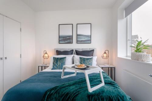 Un dormitorio con una cama con una mesa. en Luxury Serviced Apartments Stevenage, Hertfordshire, en Stevenage