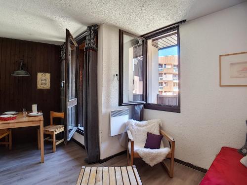 une salle à manger avec une table et une chaise dans l'établissement travelski home classic - Résidence Origanes, aux Menuires