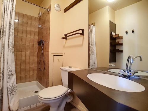 une salle de bain avec un lavabo, des toilettes et une douche dans l'établissement travelski home classic - Résidence Origanes, aux Menuires