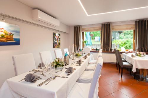 a dining room with white tables and white chairs at Landgasthof Tönnes in Wipperfürth