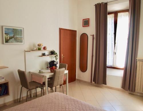 una habitación con mesa y sillas y una habitación con cama en B&B Casa Santina en Bolonia