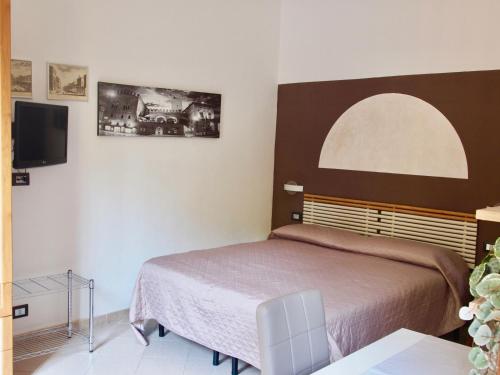 1 dormitorio con 1 cama y TV de pantalla plana en B&B Casa Santina en Bolonia