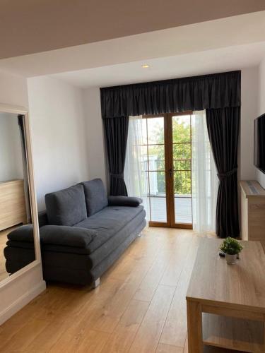 a living room with a blue couch in front of a window at ApartamentS in Râşnov