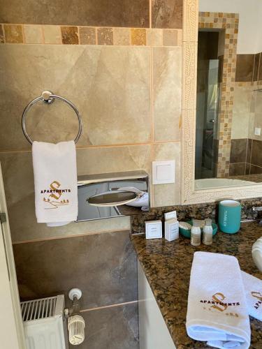 a bathroom counter with a sink and a mirror at ApartamentS in Râşnov