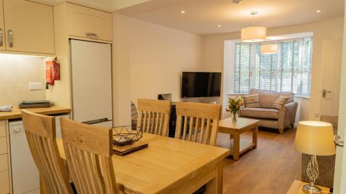 a kitchen and living room with a table and chairs at Hill Of Oaks in Windermere